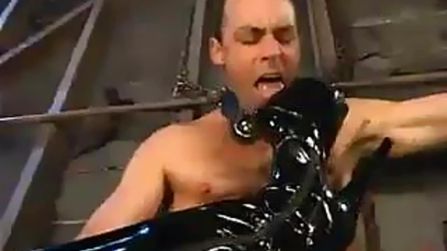 Sultry Brunette Mistress in Red Latex Bodysuit Dominates Her Submissive Guy