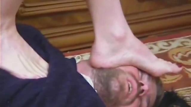 Dominant Babe With Gun Dominates His Chest Face Using Her Smelly Feet