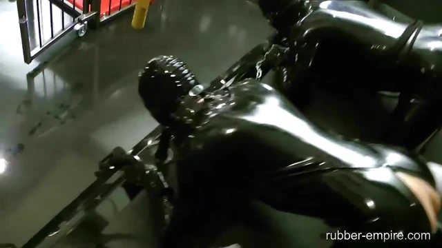 Lady Ashley Dominates Tied Friend With Strapon in Sultry Black Latex Showdown